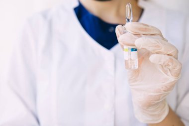 Genç doktor elinde bir ilaç şişesi tutuyor, Coronavirus.