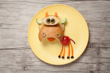 Ekmek ve taze sebze tabağı ve masa yapılmış inek