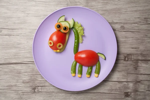 Смешная овощная лошадь, сделанная на тарелке и столе — стоковое фото