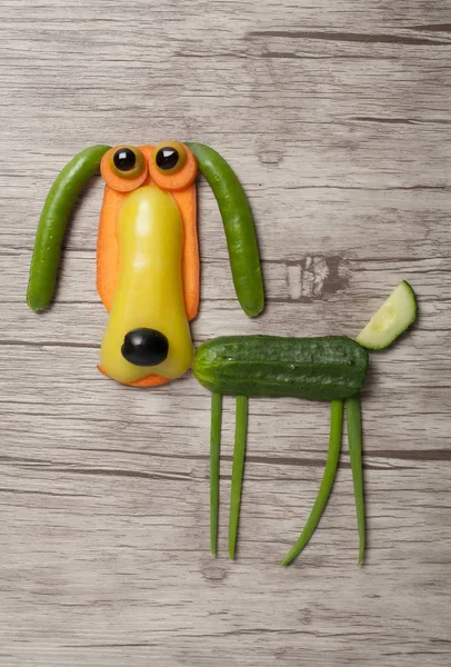 Zabawny pies warzyw wykonane na podłoże drewniane — Zdjęcie stockowe