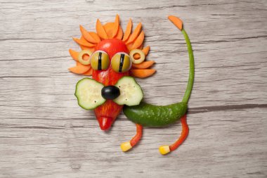 Sebze ahşap arka plan üzerinde yapılan aslan