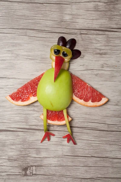 Üzgün horoz ahşap arka plan üzerinde meyve ile yapılmış