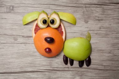 Ahşap arka plan üzerinde meyve ile yapılmış köpek