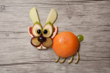 Ahşap arka plan üzerinde meyve ile yapılmış tavşan