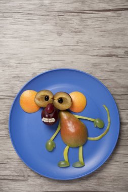 Ahşap arka plan üzerinde meyve ile yapılmış maymun