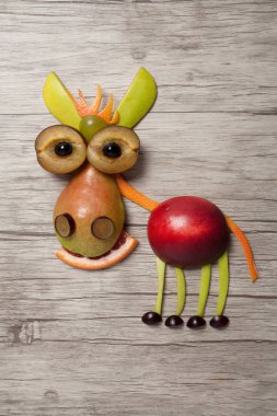 Ahşap arka plan üzerinde meyve ile yapılan eşek