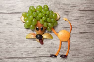 Üzüm, portakal ve ahşap zemin üzerine armut ile yapılan aslan