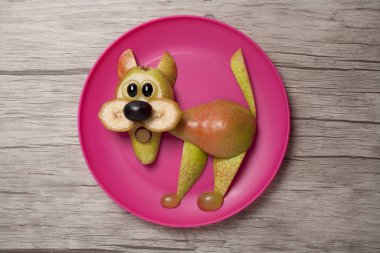 Plaka ve ahşap arka plan üzerinde komik meyve kedi