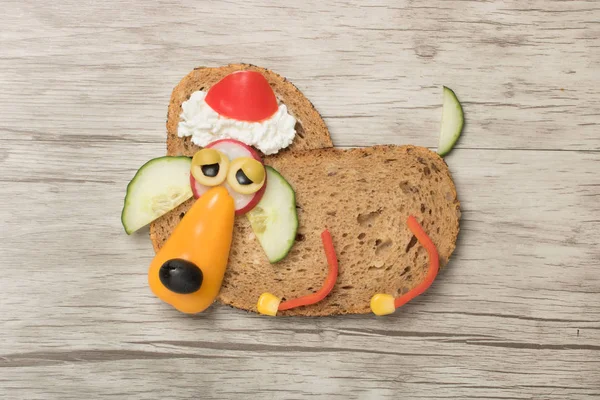 Funny festive dog in Santa hat made with bread and vegetables