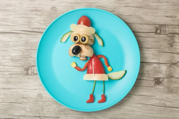Santa dog made with vegetables on blue plate