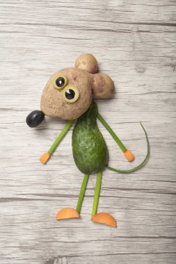 Ahşap arka planda sebzelerle yapılan komik fare.