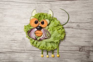 Tahtadaki sebzelerden yapılmış komik bir kedi.
