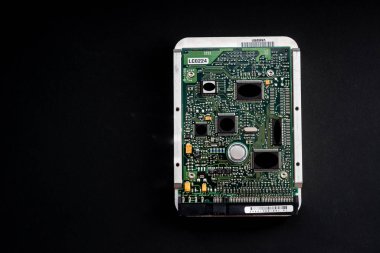 Karanlık bir arkaplanda bir sabit diskin elektronik devre kartı