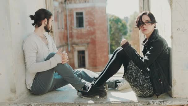 Překonání krize ve vztahu. Mladý muž a žena drží za ruce. Sedět na parapetu v opuštěné staré budově — Stock video