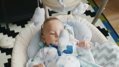 İki ay çocuk karyolası içinde yalan. Oyuncaklar, uyanık görünüyor