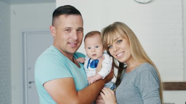 Retrato de una familia feliz, papá y el hijo de dos meses. Mirando a la cámara, sonriendo — Vídeos de Stock