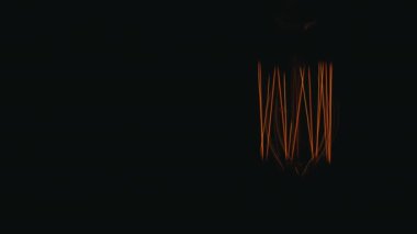 Vintage Edison lambası sürekli yanar. Siyah bir arka plan üzerinde, hafifçe sallanan