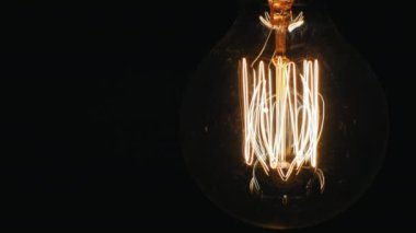 Yavaş yavaş bir dimmer kullanarak elektrik ampul yaktı. Siyah arka planda