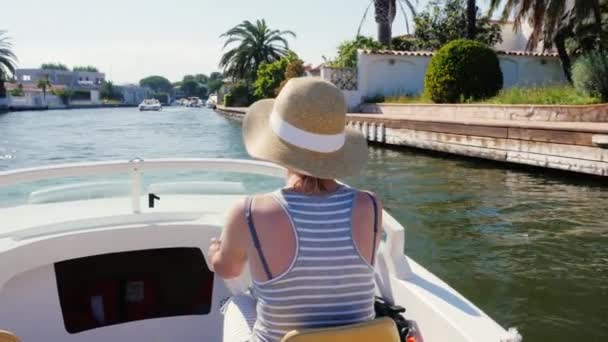 Young woman tourist rides on a motor boat on the canal. Empuriabrava, Spain. Concept: vacation in Europe, sea tour — 图库视频影像