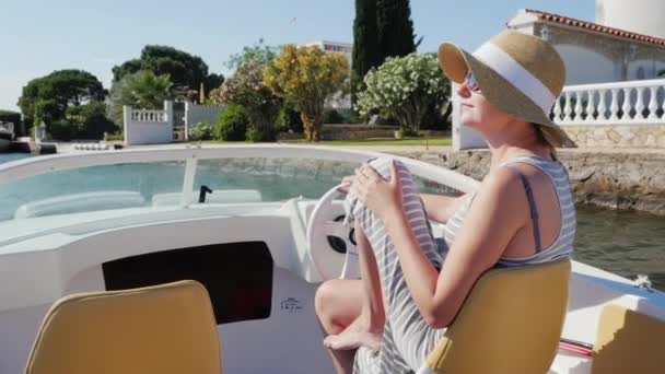 Sogni di vacanza in Europa. Donna in occhiali da sole e cappello galleggiante in una piccola barca a Empuriabrava, Spagna — Video Stock