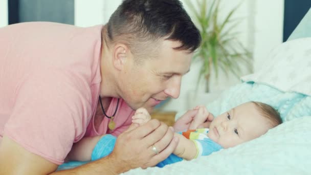 Junger Vater spielt mit seinem Sohn zwei Monate. er lächelt — Stockvideo