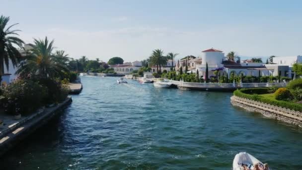 Steadicam disparó: canal con los bienes raíces de élite. Empuriabrava, España, Cataluña. Flota pequeño barco con los turistas — Vídeo de stock