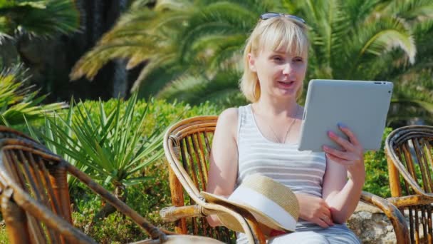 Vacaciones en un resort tropical. Siempre conectado: Mujer hablando con la tableta — Vídeos de Stock