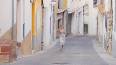 Kadın turist eski şehrin eski çeyreğinde vverhpo dar sokak var. Bir Lloret de Mar, İspanya. Avrupa'nın turizm