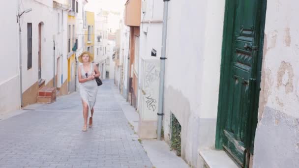 Женщина-турист стучится в закрытую дверь в старом районе города Средиземного моря. Её никто не открывает. Путешественники — стоковое видео