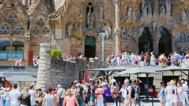 Barcelona, spanien - 20. juni 2016: viele touristen spazieren und fotografieren am eingang zur kirche der sagrada familia in barcelona — Stockvideo