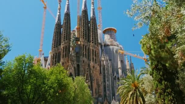 Barcelona, Spanje - 20 juni 2016: Steadicam geschoten: dichter bij de Sagrada Familia, een dynamische video met beweging van de camera. Het park is in de buurt van wandelen, toeristen — Stockvideo