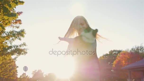 Νεαρή γυναίκα παίζει με το κουτάβι. Νηματοποίηση μαζί του στον ήλιο, βίντεο αργής κίνησης — Αρχείο Βίντεο