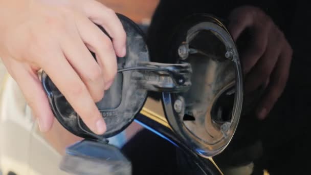 To fill the car with petrol. Open the hatch: open the lid and insert the fuel nozzle — Stock Video