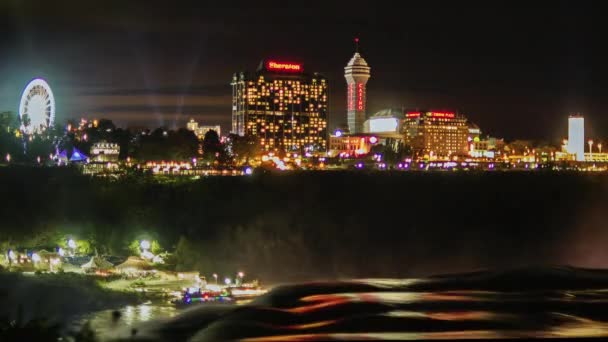 Niagara Falls, Ny, Amerikai Egyesült Államok - 2016. október 20.: Épületek kaszinók és szállás, Ferris wheel és fény show a kanadai oldalán Niagara folyó és a Niagara Falls. A turisták kedvelt helye — Stock videók