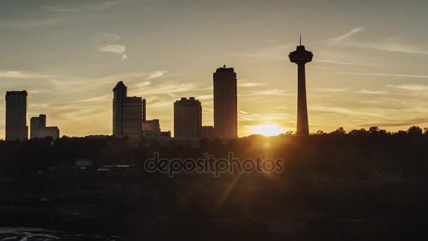 Niagara Falls nehir Kanada tarafındaki binalar üzerinde gün batımı. Amerika Birleşik Devletleri'nin Niagara Nehri üzerinden görünümden. Timelapses pan — Stok video