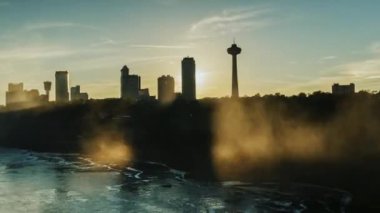 Niagara Falls nehir Kanada tarafındaki binalar üzerinde gün batımı. Amerika Birleşik Devletleri'nin Niagara Nehri üzerinden görünümden. Timelapses pan