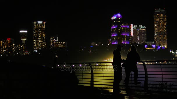 Sylwetki kobiet i mężczyzn na tle wieżowce w miasto nocą. Komunikować się, pełnej długości, wolne miejsca na tytuły — Wideo stockowe