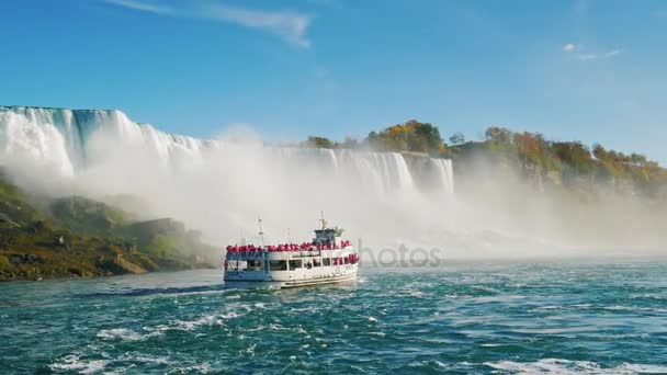 Niagara Falls, Ny - Oktober 20, 2016: Boot met toeristen drijft op de achtergrond van Niagara Falls. Onderaanzicht van de waterval. Slow-motion video — Stockvideo