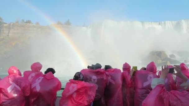 NIAGARA FALLS, NY - 20 ОКТЯБРЯ 2016: Группа туристов в красных плащах плавает на лодке у Ниагарского водопада. Восхищаясь водопадом рядом — стоковое видео