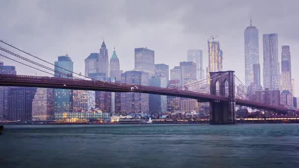 Timelapse dzień i w nocy. Deszczowa Manhattan i Brooklyn Bridge. Na szczytach wieżowców w chmurach utopić. Nadchodzi noc do biznesowej dzielnicy New York City, światła. Tam jest deszcz, ciężki — Wideo stockowe