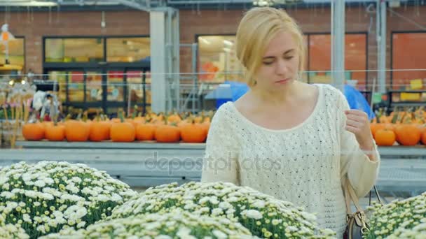 Jovem mulher atraente vê flores no berçário. Na véspera do Halloween — Vídeo de Stock