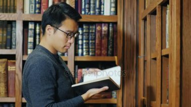 Bir kitap Kitaplığı'nda görünen akıllı Asyalı adam