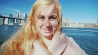 Genç çekici kadın kendini Brooklyn Köprüsü ve Manhattan arka plan üzerinde video çekimleri.