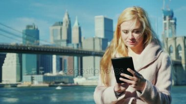 Teknoloji büyük şehirde. Genç kadının bir tabak Brooklyn Köprüsü ve Manhattan arka planı