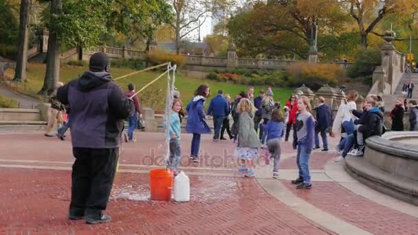 New York, Verenigde Staten - Okt, 2016: Man entertaint kids - klap bubbels in Central Park, New York — Stockvideo