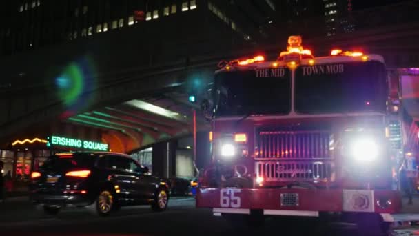 New York, Usa - Okt, 2016: Brandbil med blinkande lampor i bakgrunden är neoskrebov NewYork. Kvällens ljus lyser i Fönstren — Stockvideo