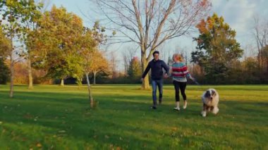 Sevgili senin köpek ile eğlenin. Parkta çalışan genç bir çok etnik gruptan oluşan Çift