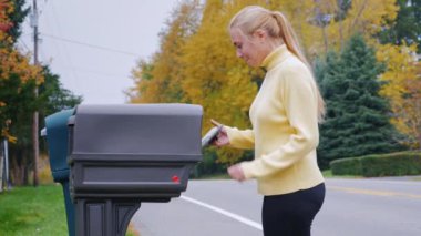 Genç kadın posta posta kutusundan alır. Kırsal kesimde ABD