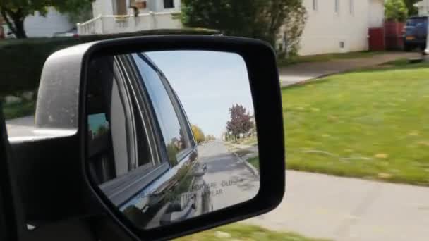 Conduciendo en un típico pueblo americano. En el marco del espejo retrovisor — Vídeos de Stock