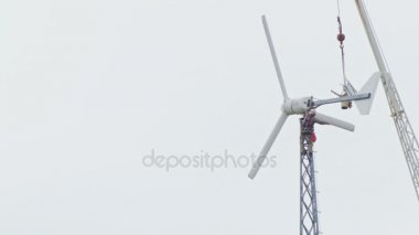 Tehlikeli bir meslek. Bir kask çalışma kulenin üzerinde bir rüzgar jeneratörü ile çalışır. Vinç malzemeleri parçalar